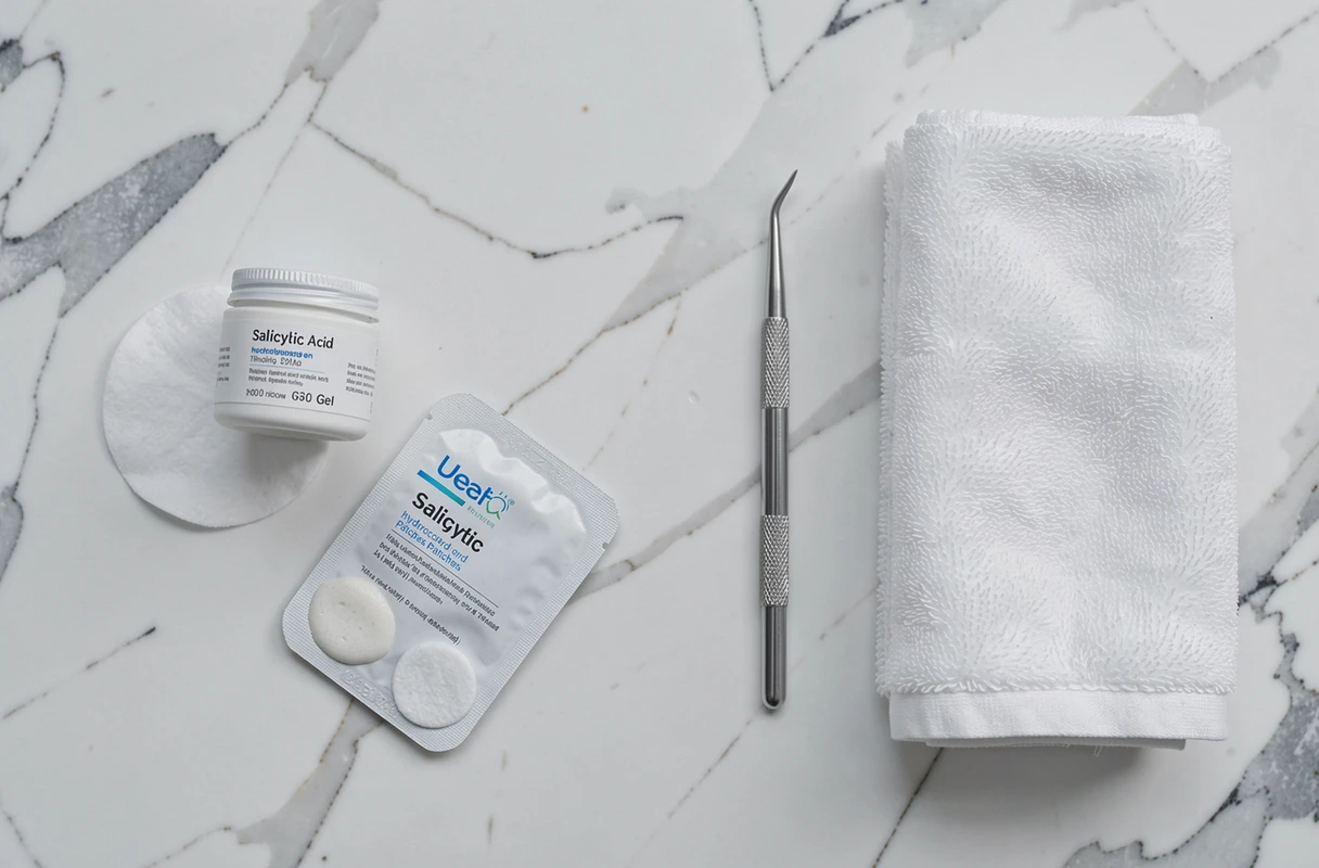 Flat lay de produits dermatologiques pour traiter un bouton de pus sur fond de marbre blanc